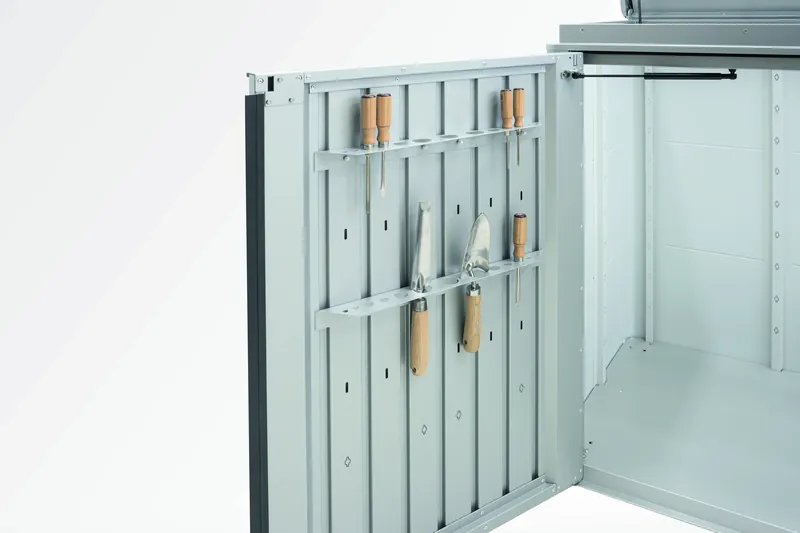 Innenseite der geöffneten Highboard-Tür mit Wandschiene und daran hängendem Gartenwerkzeug