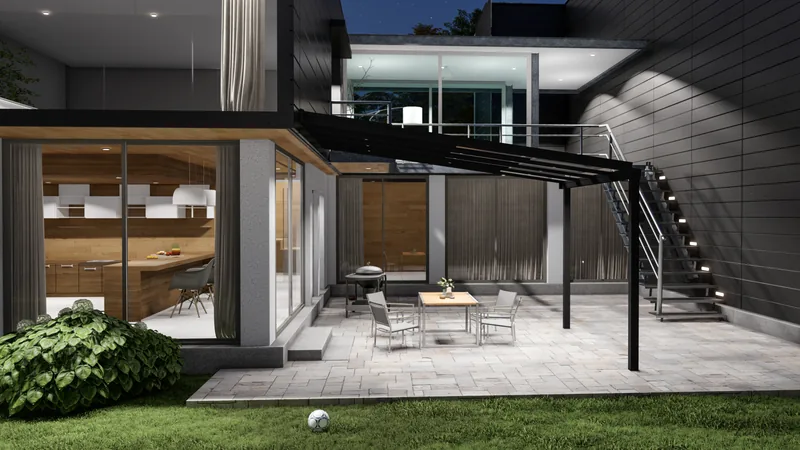 Schwarzes Schiebedach im Abendlicht an einem modernen Haus mit beleuchteter Küche, Außentreppe und Terrassenmöbeln