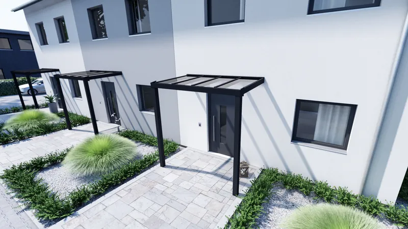 Kleines anthrazitfarbenes Vordach mit heller Eindeckung über einer Haustür an einer weißen Hausfassade, Garten mit Gräsern